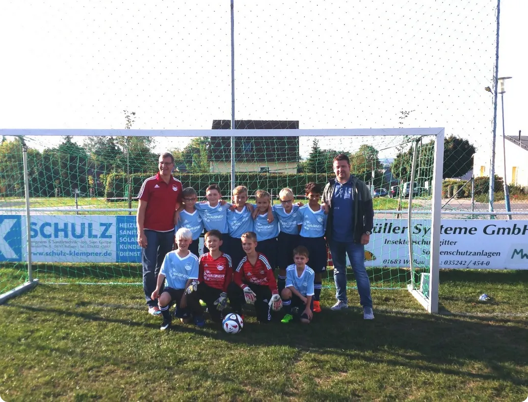 Kinder-Fußballmannschaft des SV Gleisberg – Gruppenbild im Tor mit Trainer und Sponsor